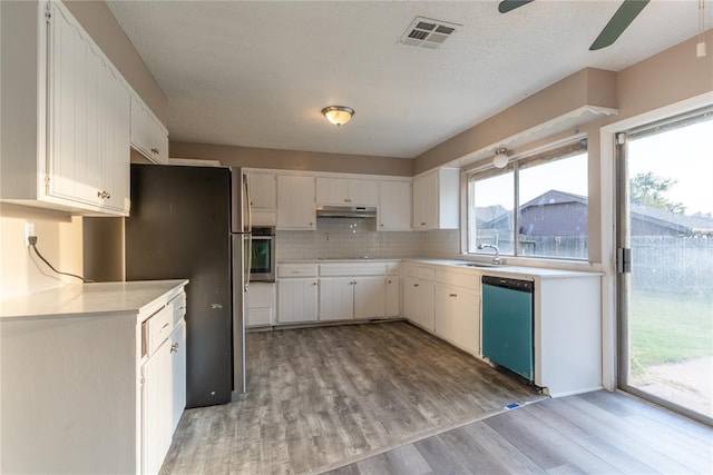 kitchen featuring sink, stainless steel appliances, decorative backsplash, white cabinets, and hardwood / wood-style flooring