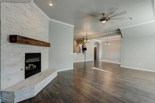 unfurnished living room with ceiling fan, dark wood-type flooring, a stone fireplace, a textured ceiling, and ornamental molding