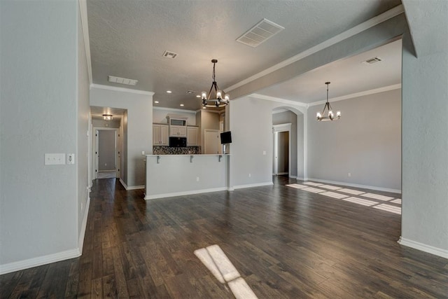 unfurnished living room featuring a textured ceiling, dark hardwood / wood-style floors, and ornamental molding