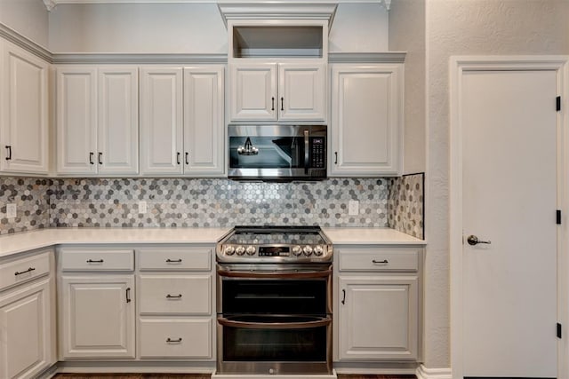 kitchen featuring decorative backsplash, white cabinetry, and appliances with stainless steel finishes