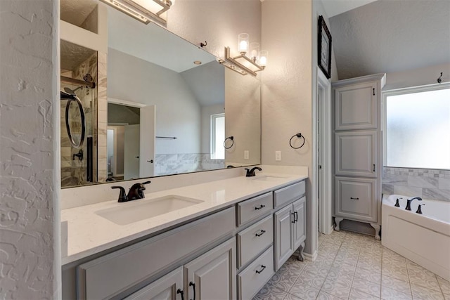 bathroom featuring tile patterned flooring, plenty of natural light, lofted ceiling, and vanity