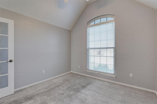 spare room featuring light carpet, ceiling fan, and lofted ceiling