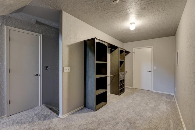 unfurnished bedroom featuring lofted ceiling, carpet, and a textured ceiling