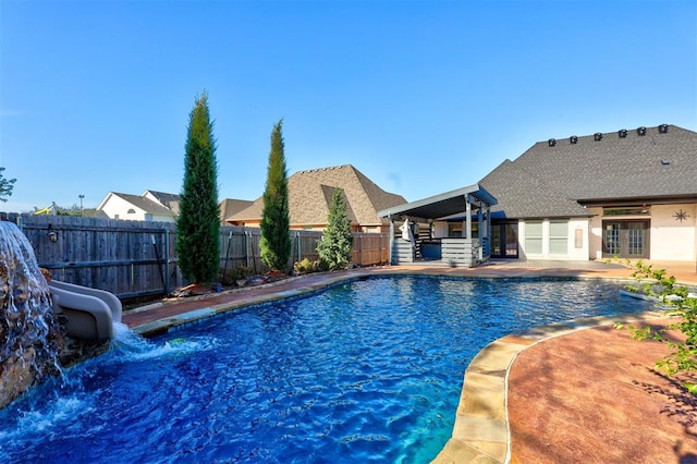 view of swimming pool featuring a patio area, french doors, and a water slide