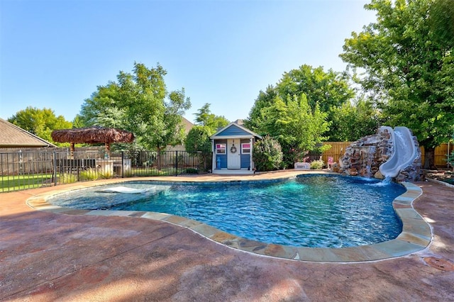 view of pool featuring an outdoor structure, a patio, and a water slide