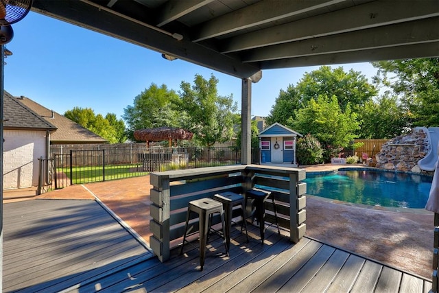 deck featuring a fenced in pool and an outbuilding