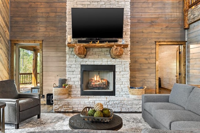 living room featuring wood walls and a fireplace