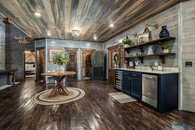 bar featuring dishwasher, blue cabinets, dark wood-type flooring, and wood walls