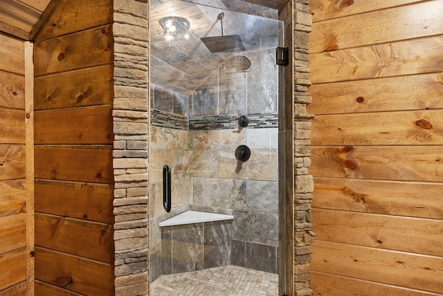 bathroom with a shower with shower door and wood walls