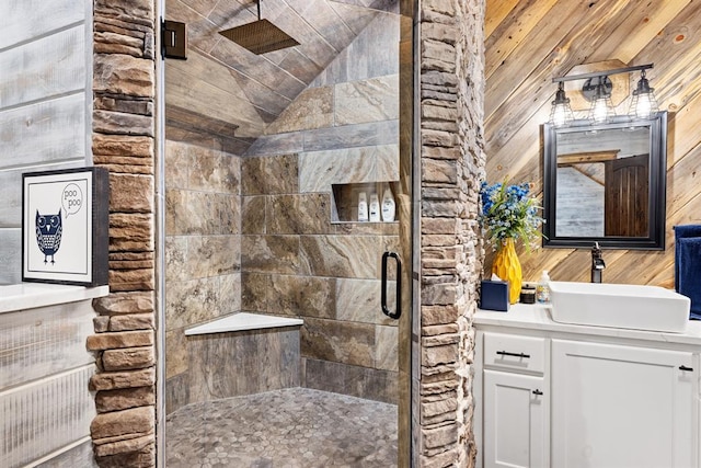 bathroom with vanity, an enclosed shower, lofted ceiling, and wooden walls