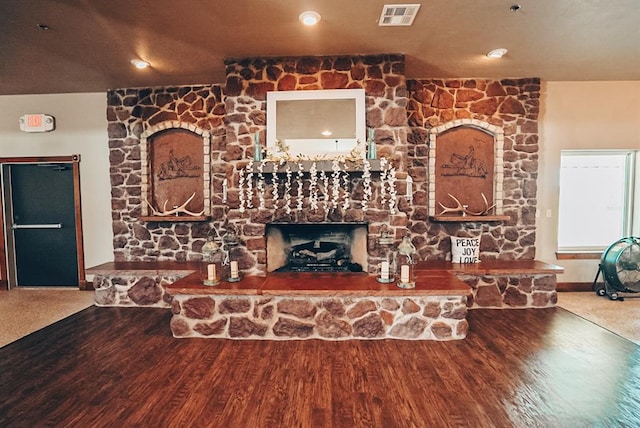 living room with a stone fireplace and wood-type flooring