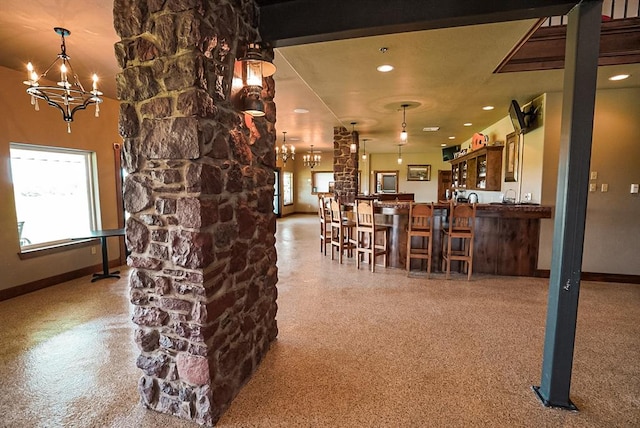 bar featuring carpet flooring, hanging light fixtures, and a chandelier
