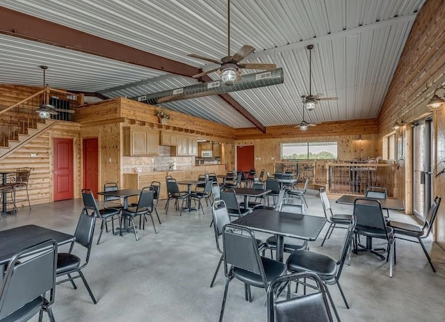 dining space with beamed ceiling, ceiling fan, concrete flooring, and high vaulted ceiling