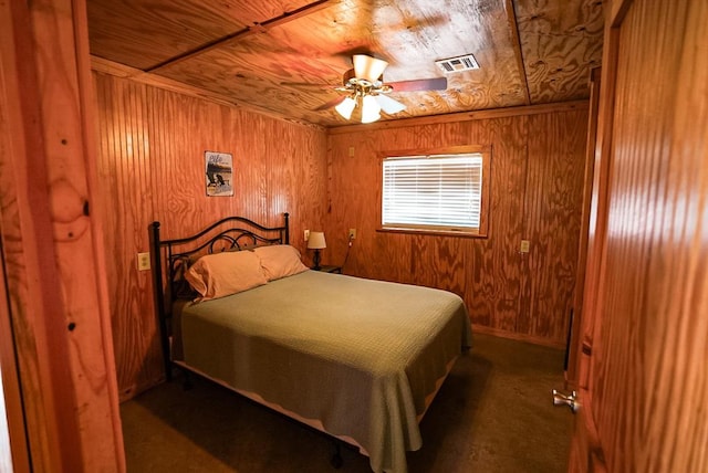 carpeted bedroom featuring wooden ceiling, ceiling fan, and wooden walls