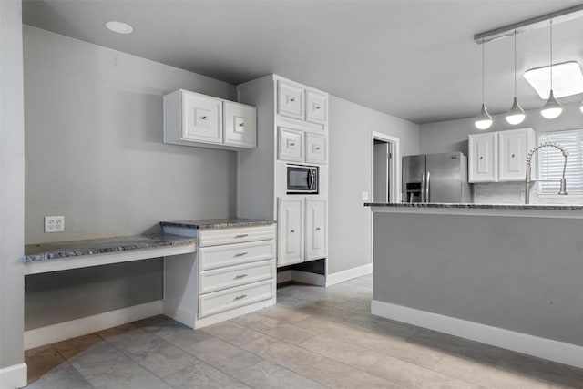 kitchen featuring white cabinetry, sink, stainless steel appliances, pendant lighting, and stone countertops