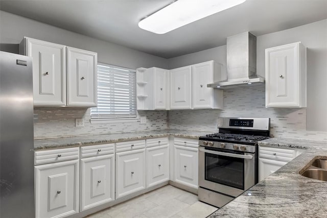 kitchen featuring white cabinets, wall chimney exhaust hood, light stone countertops, and stainless steel appliances