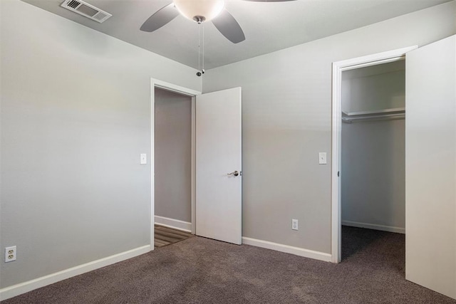 unfurnished bedroom featuring dark colored carpet, ceiling fan, and a closet