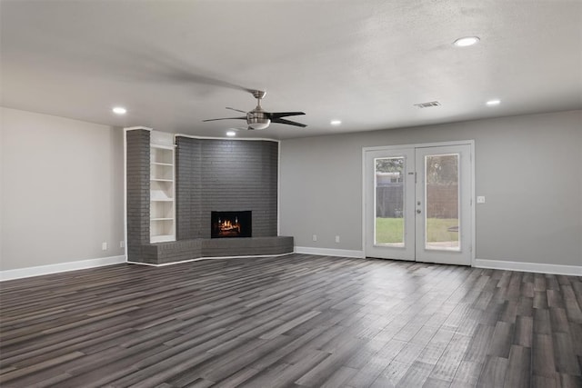 unfurnished living room with dark hardwood / wood-style floors, ceiling fan, and a fireplace