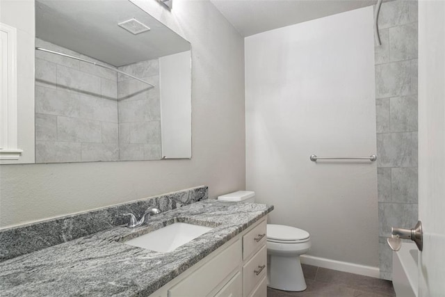 bathroom featuring tile patterned floors, vanity, toilet, and a tile shower