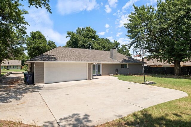 ranch-style home featuring a garage and a front lawn