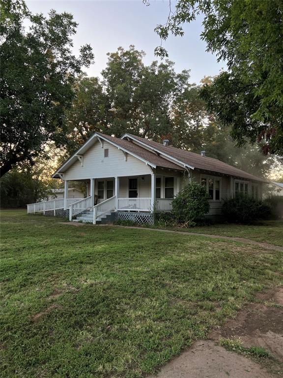 view of front facade featuring covered porch and a front lawn