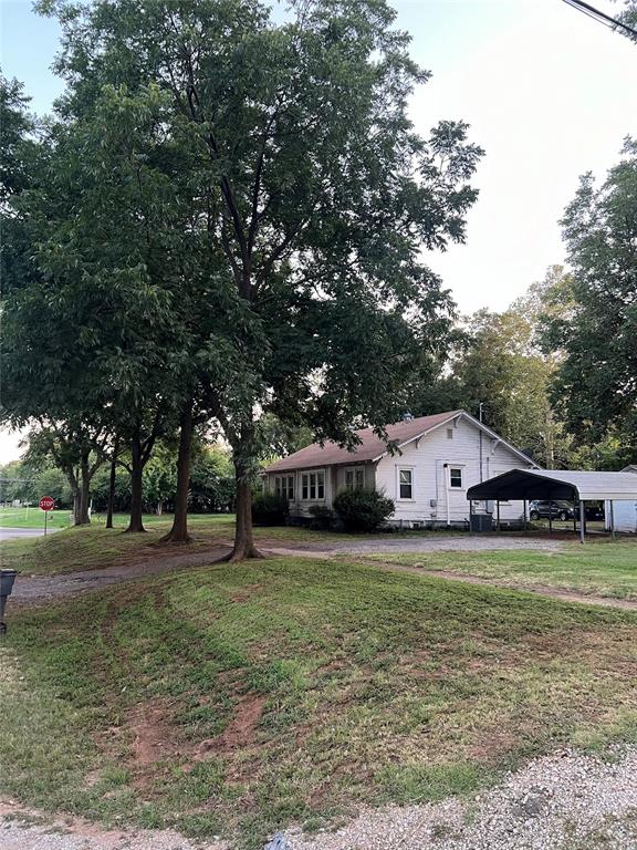 view of front of home with a carport and a front yard