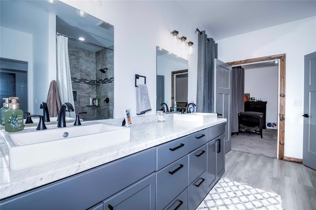 bathroom with hardwood / wood-style floors, vanity, and walk in shower