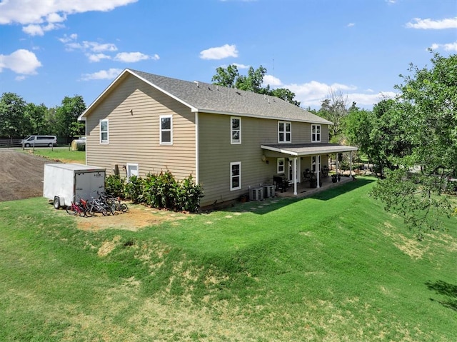 rear view of house featuring a yard, a patio, and central AC