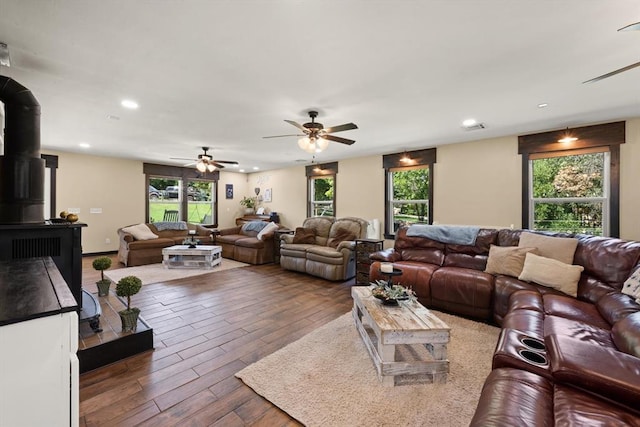 living room featuring ceiling fan, dark hardwood / wood-style flooring, and a healthy amount of sunlight