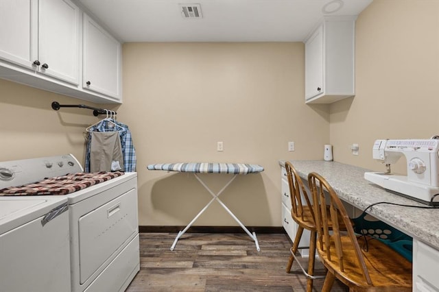 laundry area featuring cabinets, washer and clothes dryer, and wood-type flooring