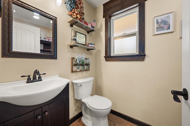 bathroom with hardwood / wood-style floors, vanity, and toilet