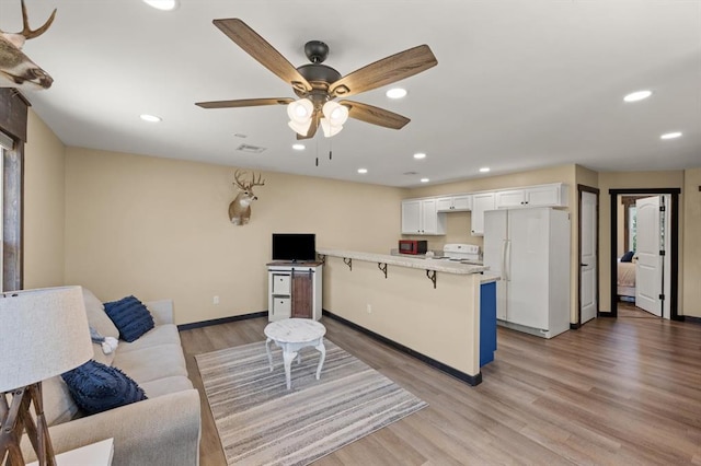 living room with light wood-type flooring and ceiling fan