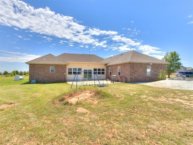 back of house featuring a patio area, a playground, and a yard