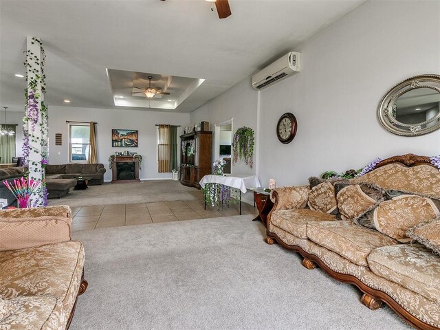 living room featuring a wall unit AC, a raised ceiling, ceiling fan, and light colored carpet