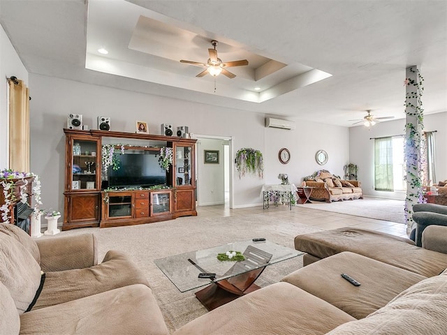 living room with a tray ceiling, ceiling fan, tile patterned flooring, and a wall mounted air conditioner