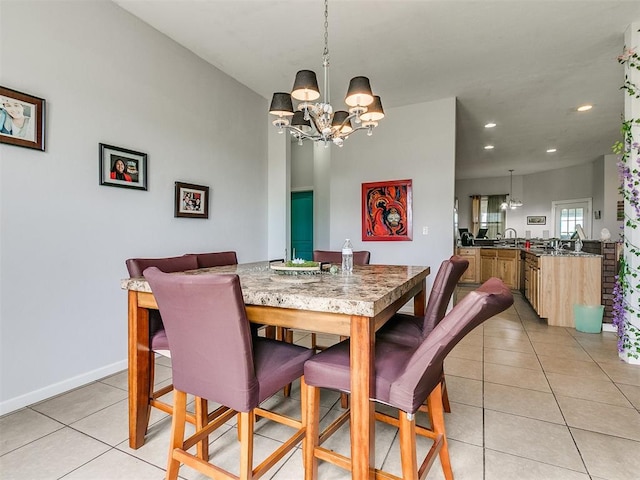 dining space featuring light tile patterned floors, sink, and an inviting chandelier