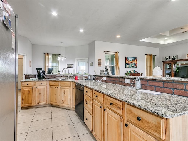 kitchen featuring a wealth of natural light, light brown cabinetry, light stone counters, and black dishwasher