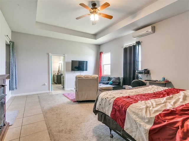 tiled bedroom featuring connected bathroom, a tray ceiling, an AC wall unit, and ceiling fan