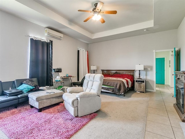 tiled bedroom featuring an AC wall unit, a raised ceiling, and ceiling fan