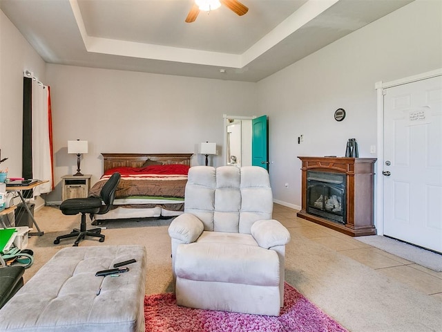 bedroom with light carpet, a raised ceiling, and ceiling fan