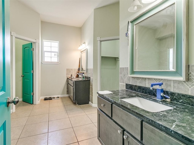 bathroom with tile patterned flooring, vanity, and tasteful backsplash