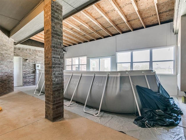 interior space with concrete floors and brick wall