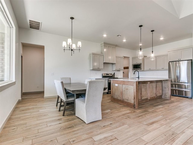 dining area with a chandelier, light hardwood / wood-style floors, and sink