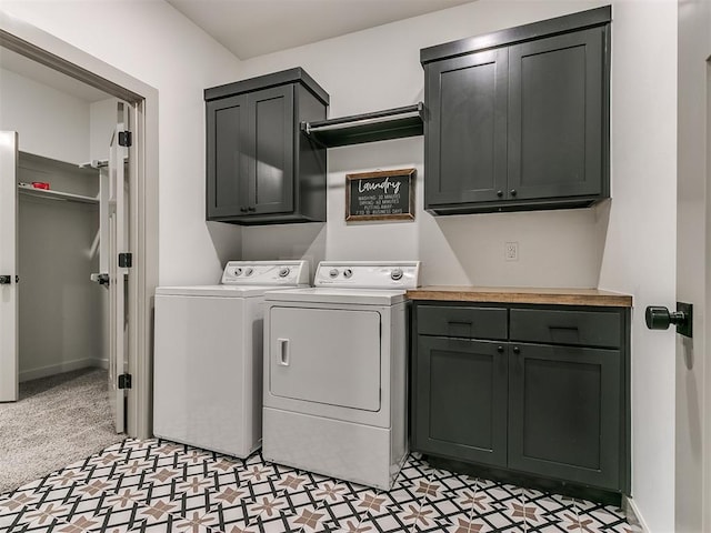 clothes washing area featuring cabinets and washing machine and dryer