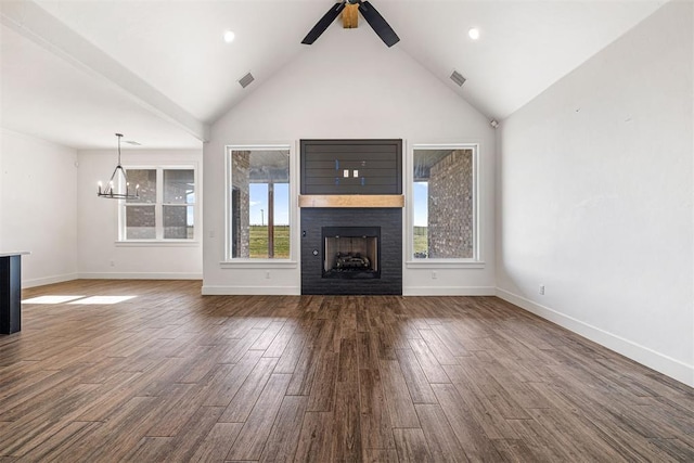 unfurnished living room featuring ceiling fan with notable chandelier, dark wood-type flooring, a fireplace, and visible vents