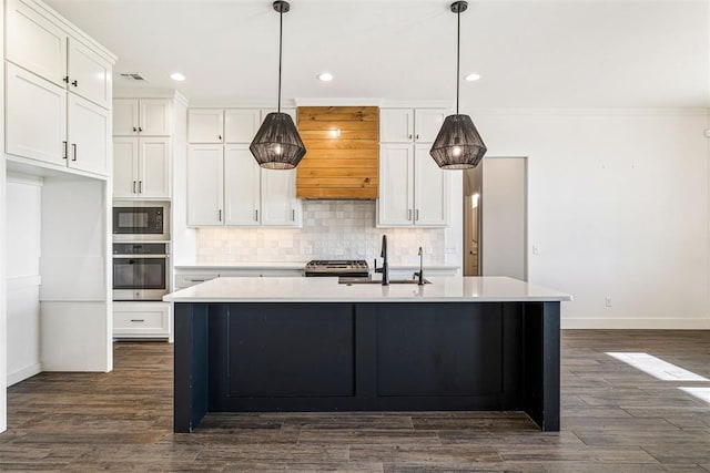 kitchen featuring backsplash, built in microwave, stainless steel oven, white cabinets, and a sink