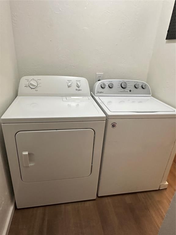 clothes washing area featuring dark hardwood / wood-style floors and separate washer and dryer