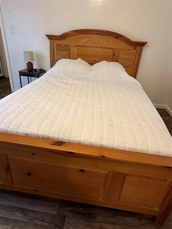 bedroom with dark hardwood / wood-style floors