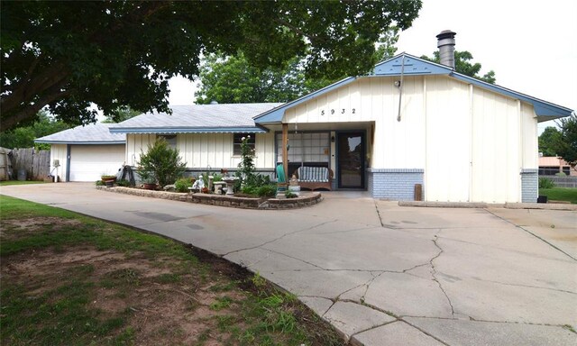 5932 NW 62nd Ter, Oklahoma City, OK 73122 - view of front of property with board and batten siding, brick siding, covered porch, and a garage