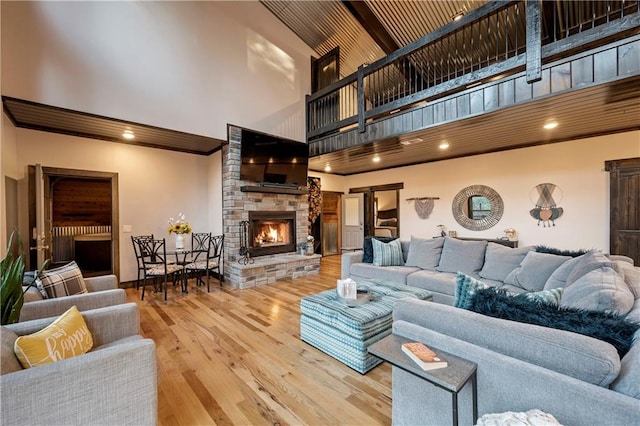 living room with a fireplace, hardwood / wood-style floors, and a towering ceiling